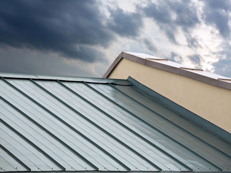 A metal roof with a cloudy sky in the background.