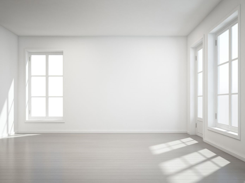 A white room with two windows and a wooden floor.
