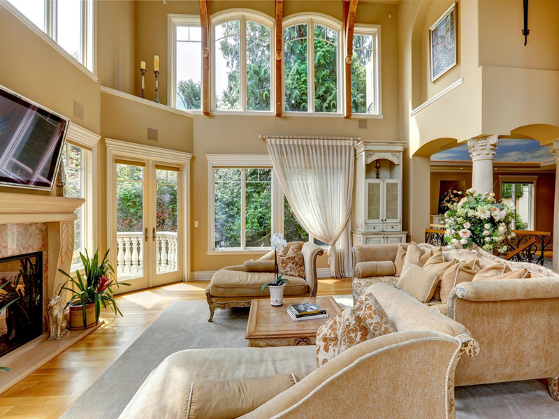 A living room with two large windows and couches
