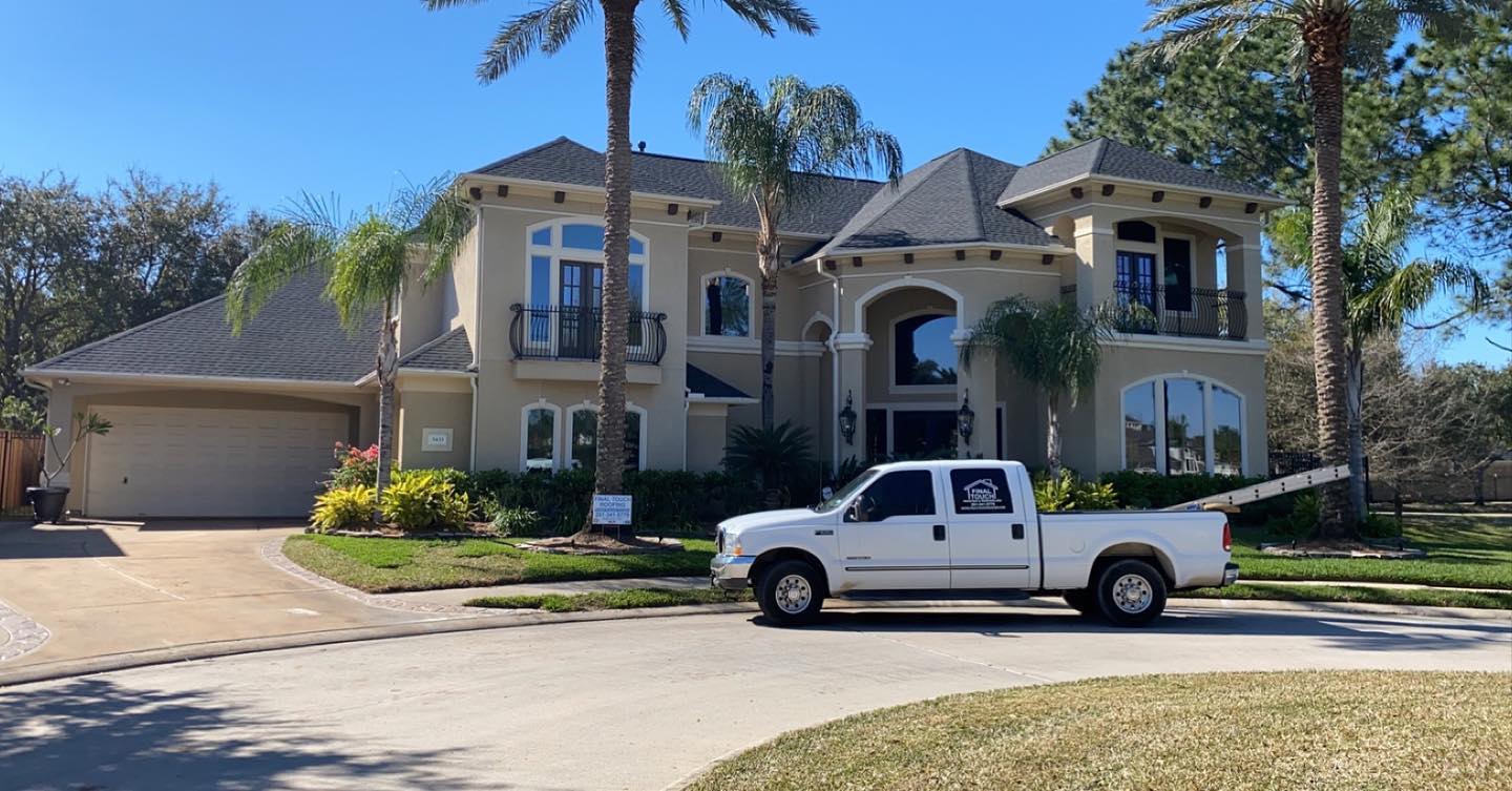 A white truck parked in front of a large house.