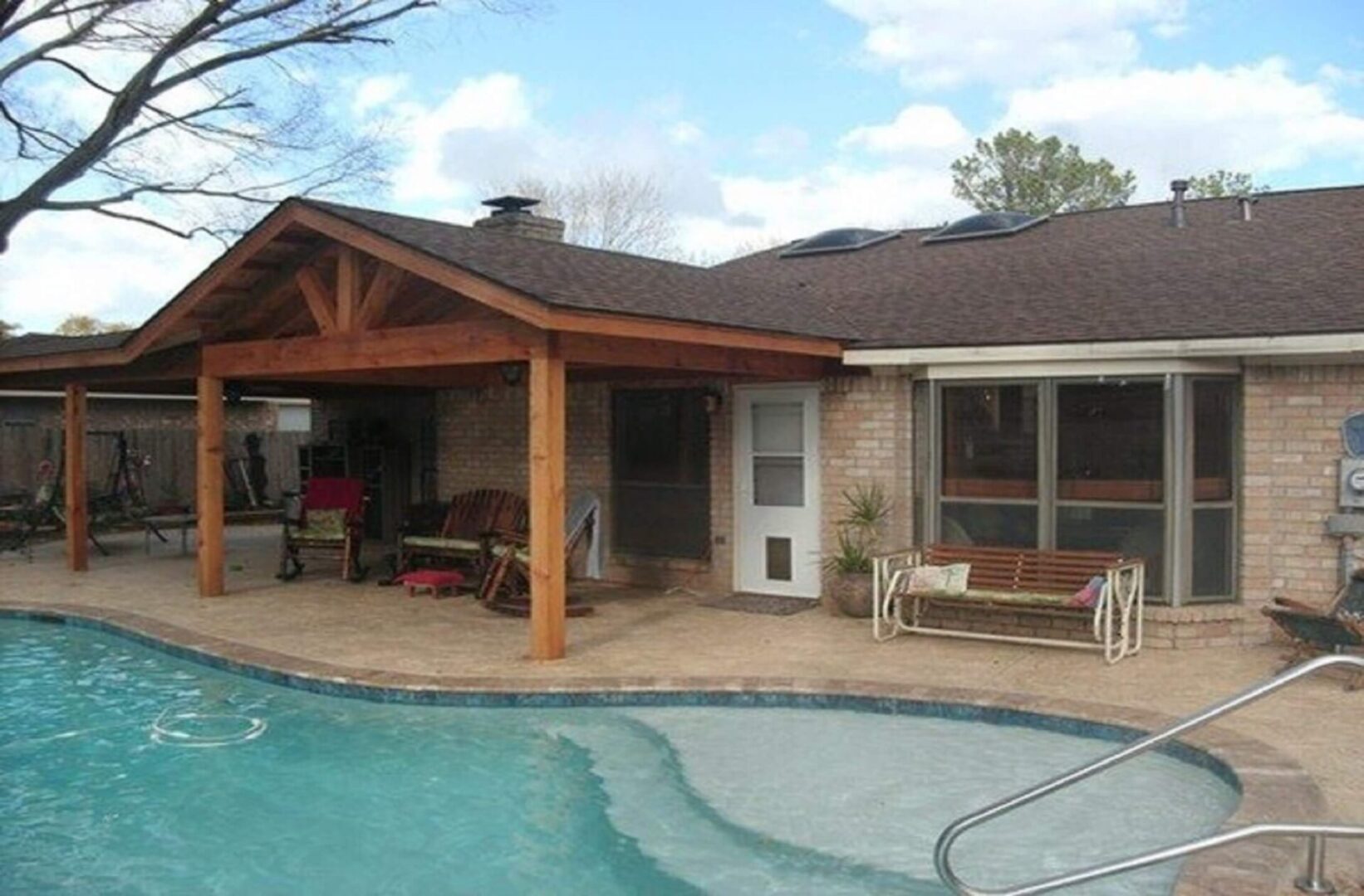 A pool house with a covered patio and swimming pool.